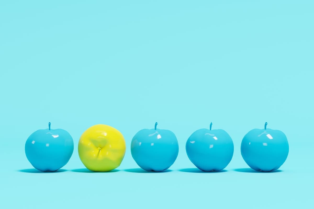 blue and yellow apples lined up in a straight line